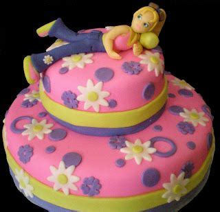 A Pink And Yellow Cake With A Girl Laying On Top