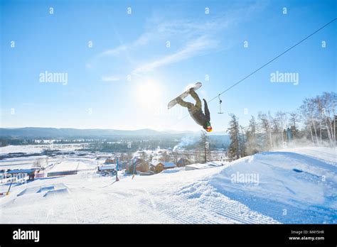 full length action shot  young man performing snowboarding stunt