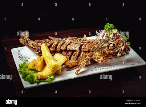 Whole Fried Fish Served With Vegetable Salad And Yucca Stock Photo Alamy