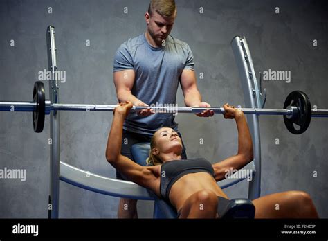 El hombre y la mujer con el barbell flexión músculos de gimnasio