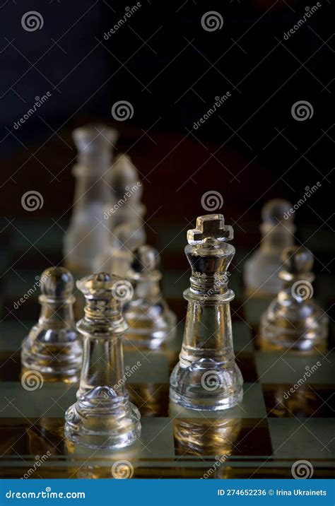 Glass Chess Pieces Are Defending The King On Board In Dark Stock Photo