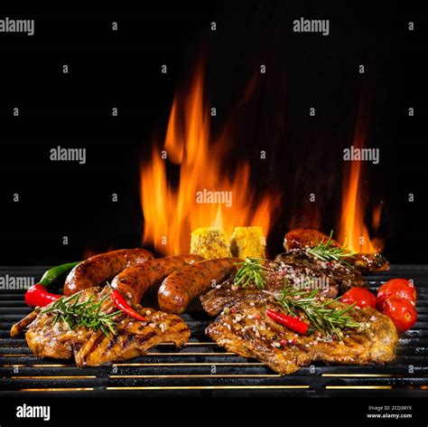 Delicious Pieces Of Meat On Grill With Fire Flames Isolated On Black