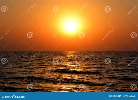 Bright Sun In Orange Sunset Sky Shining And Reflected In Red Sea In