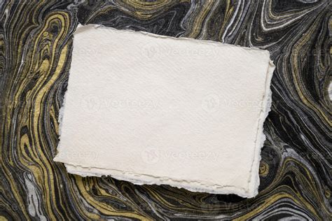 Sheet Of Blank White Khadi Rag Paper Against Abstract Black And Gold