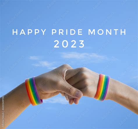 Happy Pride Month 2023 On Bluesky And Rainbow Wristband In Hands Background Concept For Lgbt