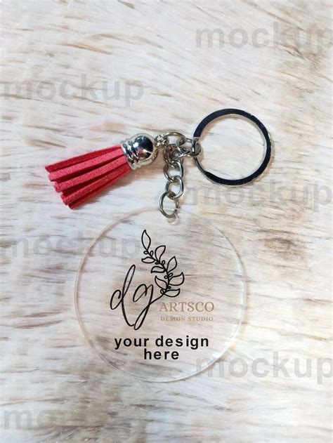 A Clear Keychain With A Red Tassel Hanging From It