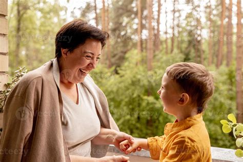 Happy Grandmother And Grandson Enjoy Time Together Positive Middle Age Woman Playing With