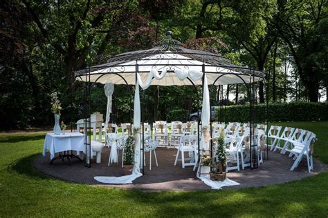 A Gazebo Set Up With White Chairs And Tables