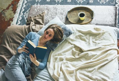 Premium Photo Young Woman Reading Book While Lying On Bed At Home