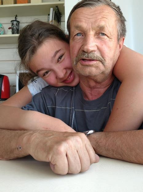 Premium Photo Smiling Granddaughter Embracing Grandfather At Home