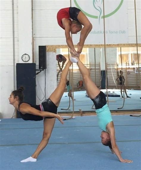 Two Women Doing Handstands In An Indoor Gym