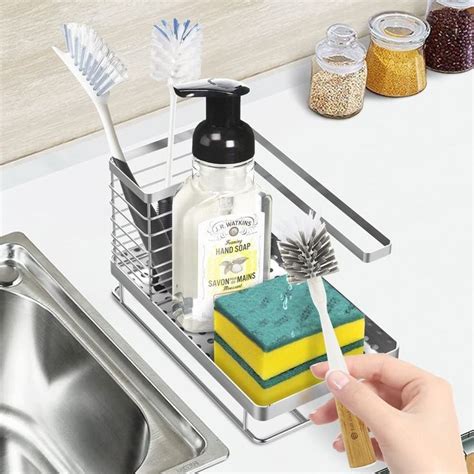 A Person Is Holding A Toothbrush In Front Of A Sink With Soap And Sponges