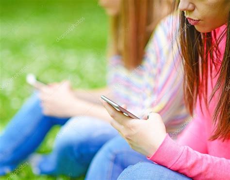 Primer plano de las manos de las adolescentes utilizando teléfonos