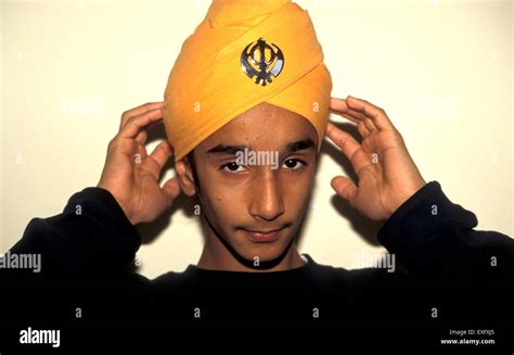 Sikh Youth Checking His Turban Which Displays The Symbol Of The Khalsa