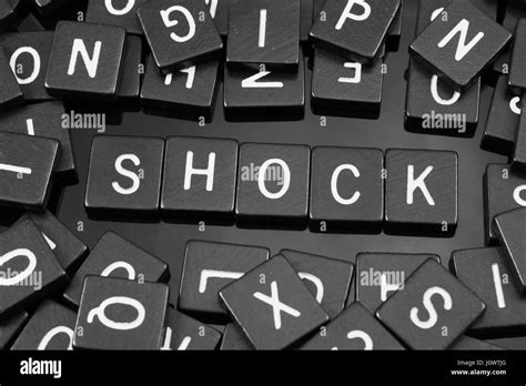 Black Letter Tiles Spelling The Word Shock On A Reflective Background