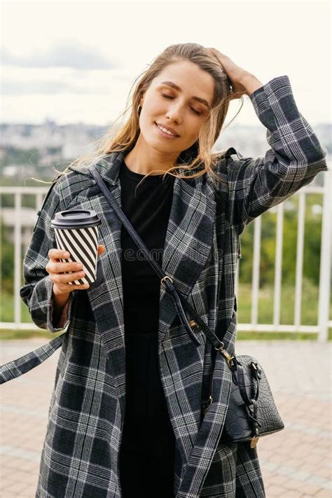 Vertical Portrait Of A Chill Woman Wearing Coat And Holding A Cup Of