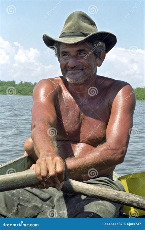 A Fisherman Rowing His Narrow Fishing Boat In The Ganges River