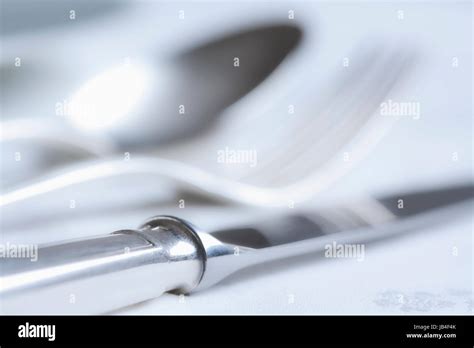 elegant table setting with silverware on white cloth Stock Photo - Alamy