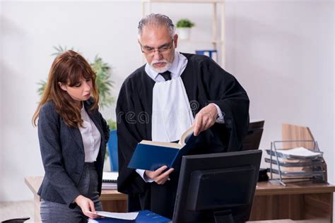 Old Male Judge And His Young Secretary In The Office Stock Photo