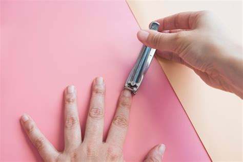 Premium Photo Close Up Of Woman Cutting Nails Against Colored Background