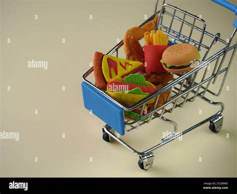 Closeup image of shopping cart full with junk foods like burger, fries ...