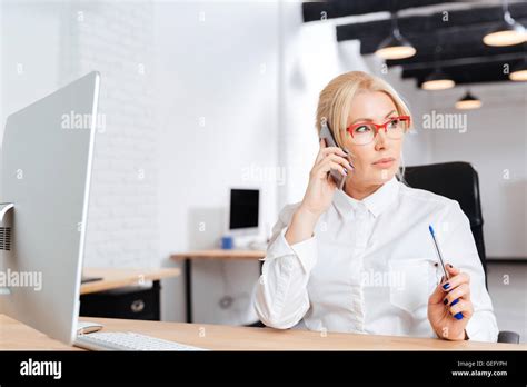 Beautiful Mature Business Woman Talking On Phone In The Office Stock