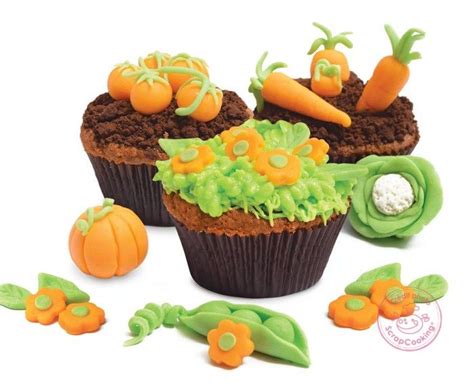 Cupcakes Decorated With Green Icing And Carrots Are On The White Surface