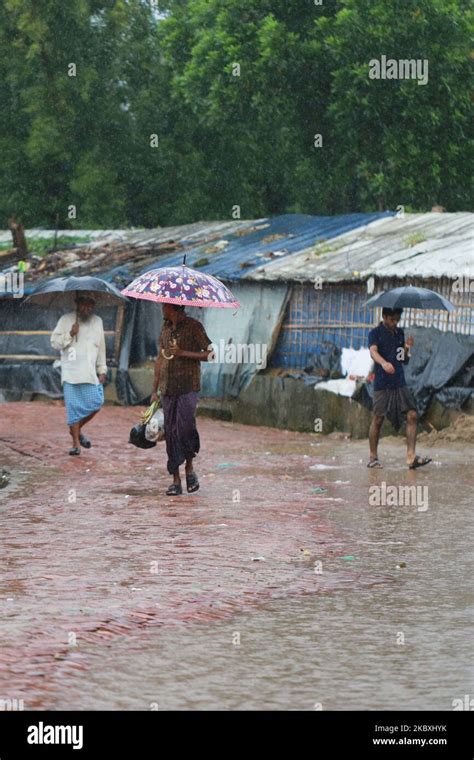 Rohingya Refugees Walk During A Monsoon Rain At Kutupalong Refugee Camp