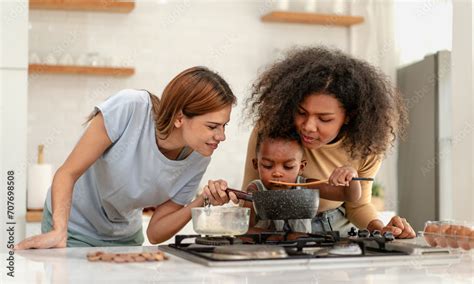 Multiracial Lesbian Couple Cooking Healthy Food In Kitchen For Their Biracial Boy Gay Women