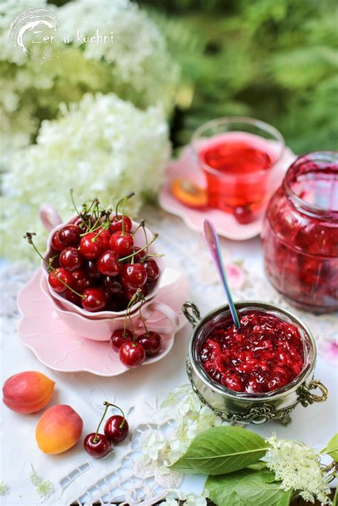 Cherries Are Sitting In Small Bowls On A Table Next To Flowers And