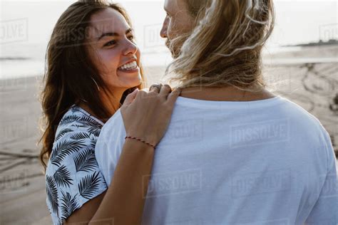 Smiling Couple Hugging And Looking At Each Other On Beach In Bali