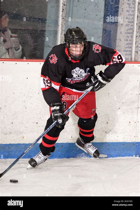 Teenage Ice Hockey player skating with puck Stock Photo - Alamy