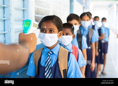 School kids with medical face mask being test with temperature before ...