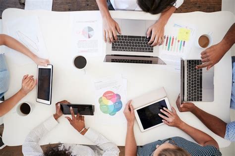 Premium Photo Business People Using Computers At A Desk Overhead Shot