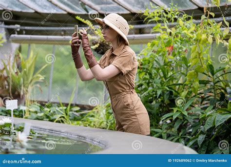 Woman Botanist Dressed In Safari Style In Greenhouse Naturalist In