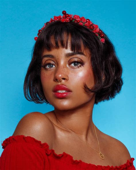 a woman wearing a red dress with a flower crown on her head, against a ...