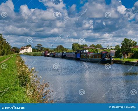 A Row Of Canal Narrowboats Moored At Permanent Moorings On A Quiet