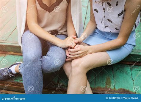 Two Hipster Girls Are Holding Hands Together Outdoors Woman Sitting On The Bridge Support And