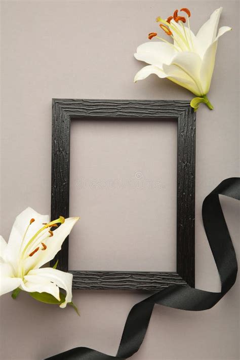 Beautiful Lily Flower with Blank Frame and Black Funeral Ribbon on Grey Concrete Background. Top ...