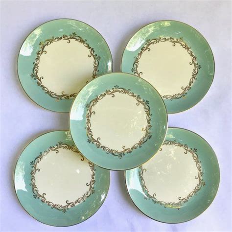 Four Green And White Plates Sitting On Top Of Each Other