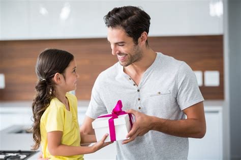 Premium Photo Smiling Daughter Giving Gift Box To Father