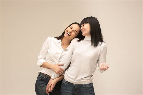 Un Retrato De Una Feliz Madre E Hija En El Estudio En Gris Foto Gratis