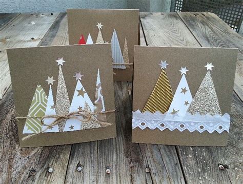 Two Christmas Cards With Trees On Them Are Sitting On A Wooden Table