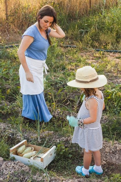 Free Photo Mother And Daughter Standing In Field Harvesting Fresh Vegetable