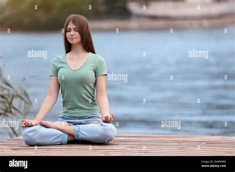 Teenage Girl Meditating Near River Space For Text Stock Photo Alamy