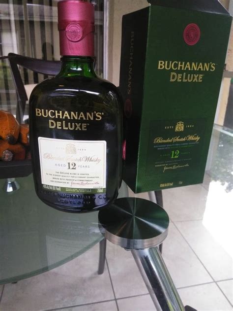 a bottle of buchanna's deluxe is sitting on a glass table