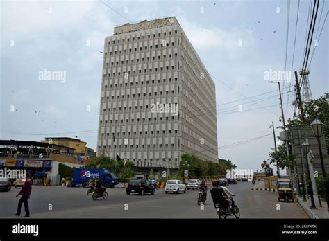 Motorcyclists and vehicles ride past a head office building of Dawood ...