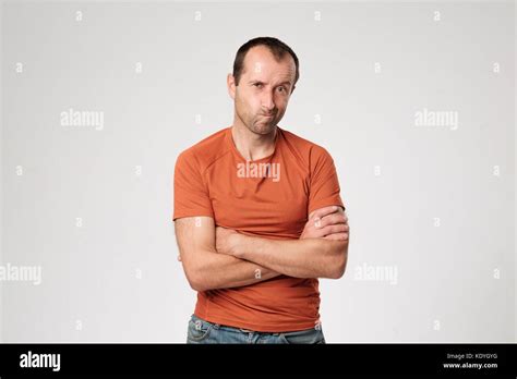 Isolated Portrait Of Angry Man Wearing Orange T Shirt Holding Arms