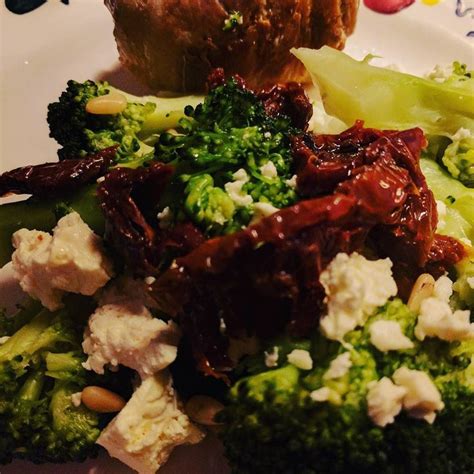 A White Plate Topped With Broccoli And Other Vegetables Next To A Muffin