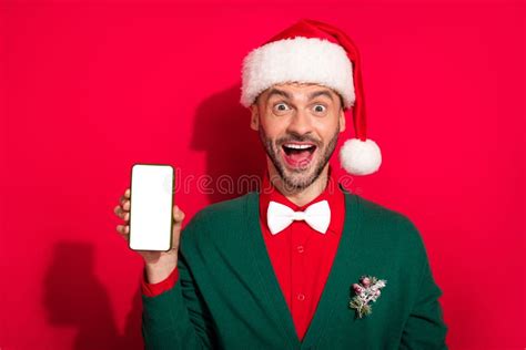 Photo Of Handsome Impressed Guy Dressed Xmas Green Cardigan Bowtie Showing Modern Gadget Empty